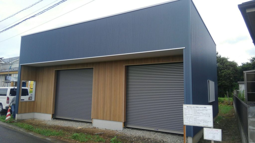 紺色のサイディングがベースで、正面出入り口は木目のサイディングで仕上げました。お客様はだいぶ悩みましたが、この組み合わせでバッチリでしたね！カッコよくなりました♪