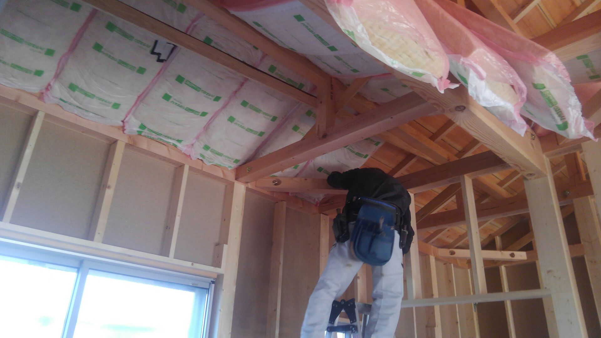 屋根工事が終わり、大工さんが天井（屋根）断熱材入れを始めました。キッチリキッチリ丁寧に。